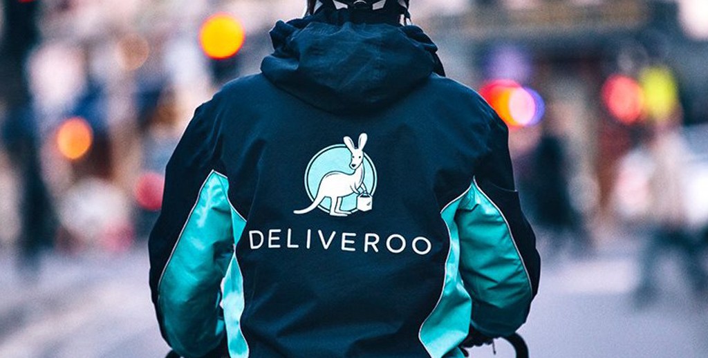 Deliveroo Rider on a street riding with a jacket on