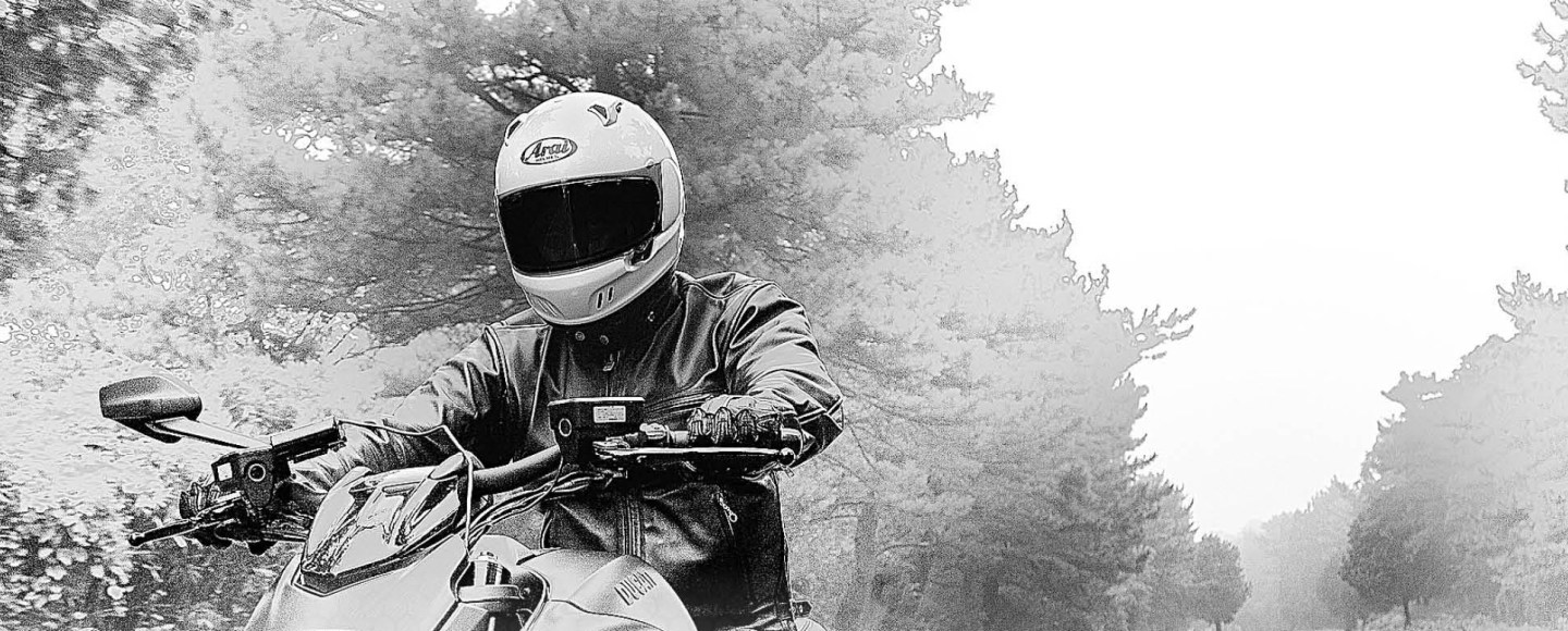 Motorcyclist riding through a forest road with arai helmet