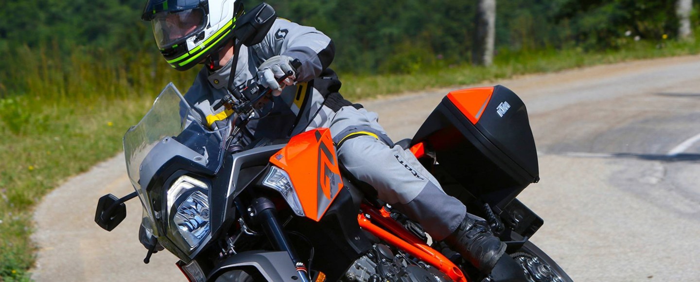 Man on motorcycle riding on a road with an arai helmet on