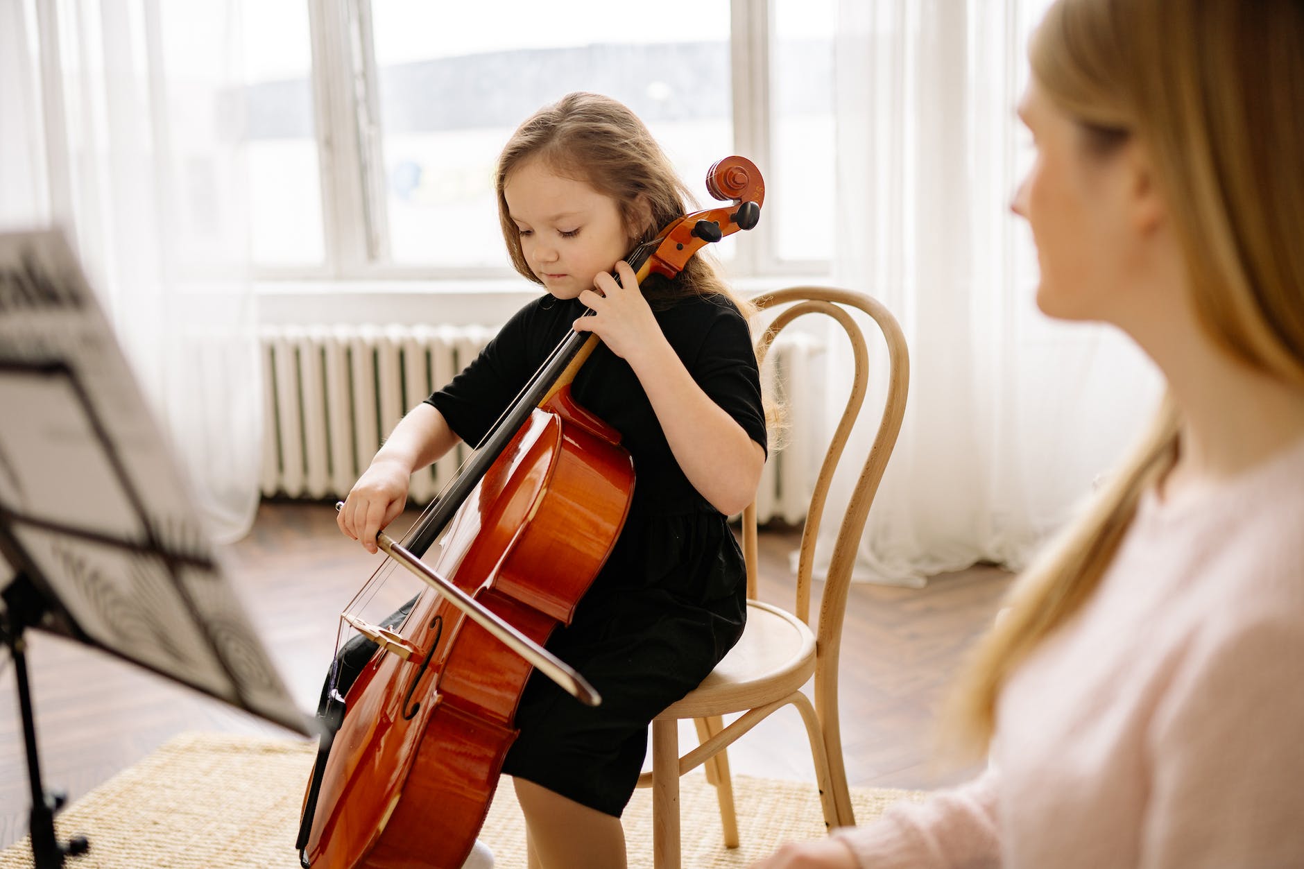 a lady teaching a small child a musical instrument