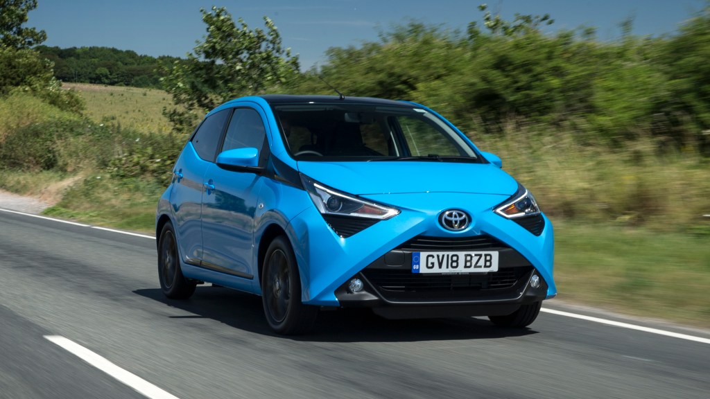 blue Toyota Aygo being driven along a country road